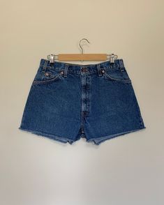 "High waisted 90's denim shorts. Made by Levi's in light dark denim wash. Shorts are in excellent clean condition. Perfectly worn in with light naturally distressed character. These have been cut off and washed once. Measurements are taken zipped or buttoned up and laid comfortably flat then x 2 for total circumference (inches) Levis 550 Tag Size 34 100% Cotton Waist 33\" Hips 45\" Length 14\" Inseam 2.5\" Rise 12.5\" leg opening circumference 25.5\" All items are free of rips, tears, holes, and Vintage Medium Wash Relaxed Fit Shorts, Vintage Dark Wash Mid-rise Shorts, Retro Denim Blue Jean Shorts, Vintage Style Mid-rise Dark Wash Shorts, Vintage Cutoff Jeans With Built-in Shorts, Vintage High-waisted Dark Wash Jean Shorts, Vintage Dark Wash Jean Shorts For Summer, Retro Blue Cutoff Shorts, Vintage Denim Blue Bottoms For Summer