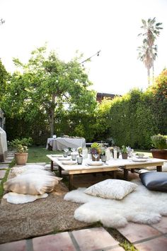 an outdoor dining area with white sheepskin rugs