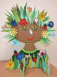 a child's head made out of paper with flowers and ladybugs on it