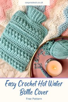 crochet hot water bottle cover is shown next to a plate with a candle