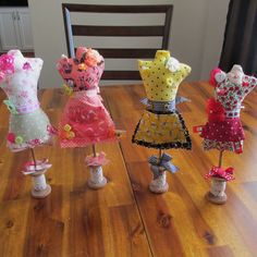 five little doll dresses are sitting on top of each other in the shape of mannequins