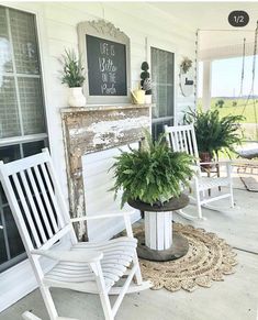 two white rocking chairs sitting on top of a porch next to a potted plant