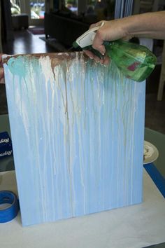 a person is painting a blue box with white paint