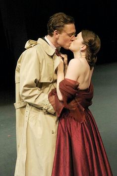 a man and woman kissing each other on stage