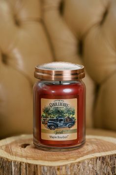 a candle sitting on top of a wooden table next to a chair and leather couch