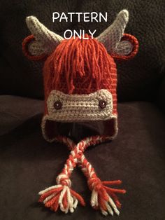 a knitted red and white hat with horns on it's head sitting on a couch