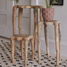 two wooden stools sitting next to each other on a rug