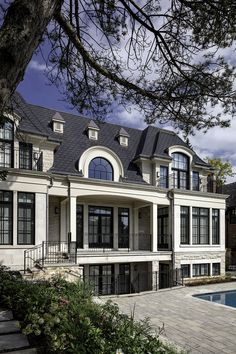 a large white house sitting next to a swimming pool