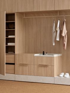 a bathroom with wooden cabinets and white towels hanging on the hooks in front of it