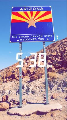 a road sign on the side of a mountain with a sky in the back ground