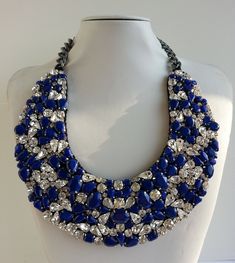 Each piece of our statement necklaces is handmade and one of a kind made in Italy. Our creations is made of high quality materials such as crystals and rhinestones. Each embroidered material is carefully hand sewn. Very glamorous and stylish. Perfect gift to someone you like. Materials Strass stones in Crystal color in different shape and dimension. Enamel stones in Cobalt color.  Black satin fabric backing. Aluminium chain with lobster closure. Measurements Weight approximate 220 grams. Chain lenght 27 cm - 10.62 in Circumference approximate 78 cm - 30.70 in Feel free to contact us if you have any question. Thank you so much for looking at our shop and our articles each of them, single piece. Crystal Necklaces With Sparkling Stones, Blue Crystal Beaded Necklaces For Party, Blue Crystal Beaded Necklace For Party, Bridal Crystal Necklace With Jewels, Crystal Rhinestone Necklace For Party, Crystal Rhinestone Necklace For Costume Occasions, Costume Jewelry Crystal Necklace With Rhinestones, Glamorous Crystal Necklace With Stones, Costume Crystal Necklaces With Sparkling Stones