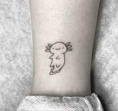 a black and white photo of a small tattoo on the ankle with a bird flying above it