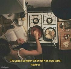 a woman reading a book in front of an oven with food on the stove top