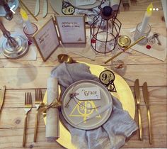 the table is set with gold and white plates, silverware, napkins, and place settings