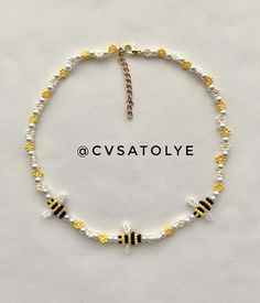 a yellow and white beaded bracelet with black and white beads on the clasp,