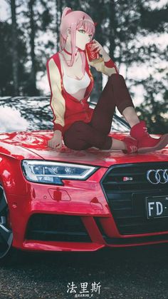 a woman sitting on the hood of a red car