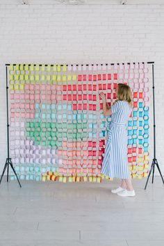 a woman standing in front of a colorful wall