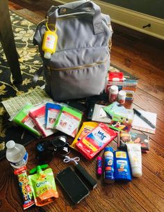 the contents of a diaper bag are laid out on the floor