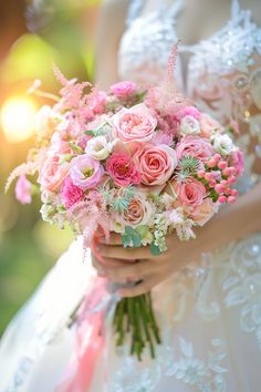 a bride holding a bouquet of pink flowers