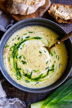 a bowl filled with soup next to some bread