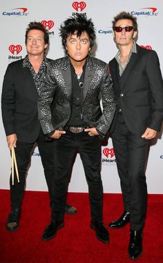 two men in suits and sunglasses standing on a red carpet