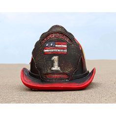 a fireman's hat with the number one on it sitting in the sand