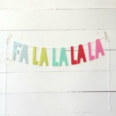 the word fala alla spelled in multicolored letters on a white wooden background