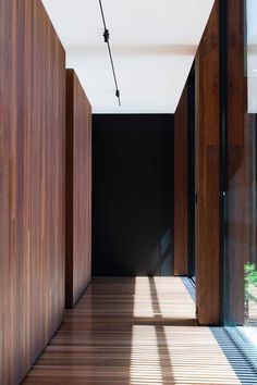 an empty hallway with wooden walls and flooring