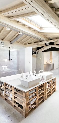 a large bathroom with two sinks and wooden pallets