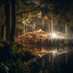 a group of people standing in front of a tent at night with lights on the trees