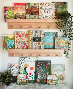 several books are arranged on wooden shelves above a white furnishing and potted plant