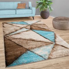 a living room with a blue couch and brown area rug on top of the floor