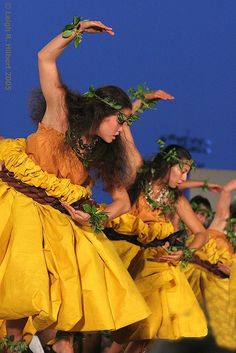 a group of women in yellow dresses dancing