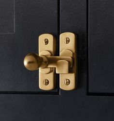 a close up of a door handle on a black door with gold handles and knobs