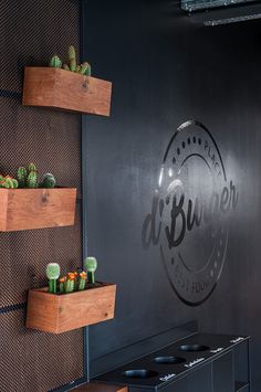 the restaurant is decorated with wooden shelves and succulents on the wall behind the counter