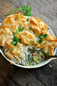 a white bowl filled with food on top of a wooden table