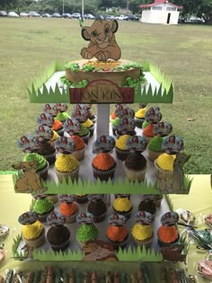 cupcakes are arranged in the shape of an animal on top of a sign