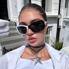 a woman wearing sunglasses and a star necklace