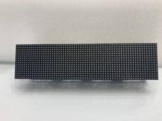 the back side of an electronic device on a white surface with black and white dots