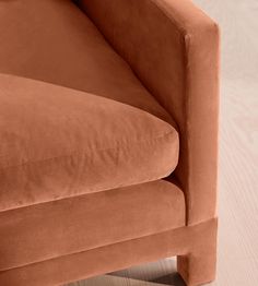 an orange couch sitting on top of a wooden floor