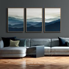 three paintings hang on the wall above a couch in a living room with hardwood floors