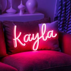 a red couch with a pillow that says kalya on it in front of a purple background