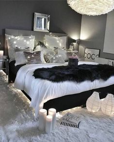 a bedroom decorated in black and white with lights