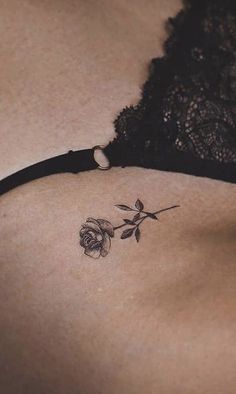 the back of a woman's stomach with a rose tattoo on her left side