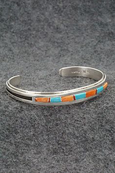 This beautiful turquoise, coral, spiny oyster and sterling silver bracelet was expertly crafted by Navajo silversmith Wilbert Muskett Jr. The inside of the bracelet is signed WM and stamped sterling.Size: 5 1/8" (will fit up to a 6 1/4" wrist)Gap: 1 1/8"Width: 3/8"Free shipping on all orders! We ship with USPS and always include tracking. All orders ship within a day of payment.Returns are accepted up to 30 days after you receive your order. Just send us a message. Our shop offers cash back or store credit. The item must be returned in new condition. Multicolor Sterling Silver Bracelet With Inlay, Multicolor Inlay Sterling Silver Bracelets, Multicolor Sterling Silver Bracelets With Inlay, Southwestern Multicolor Bracelets With Inlay, Southwestern Sterling Silver Inlay Bracelet Gift, Bear Carving, Spiny Oyster, Pearl Chain, Multi Stone