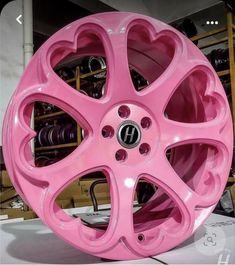 a pink car wheel with hearts painted on the front and back rims is shown