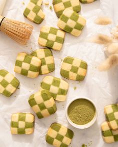 green and white checkered cookies next to a cup of powder