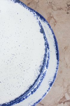 three plates sitting on top of each other with white and blue speckles around them