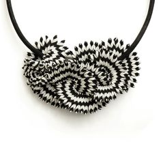 a black and white necklace with two spirals on it