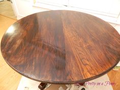 a round wooden table sitting on top of a hard wood floor